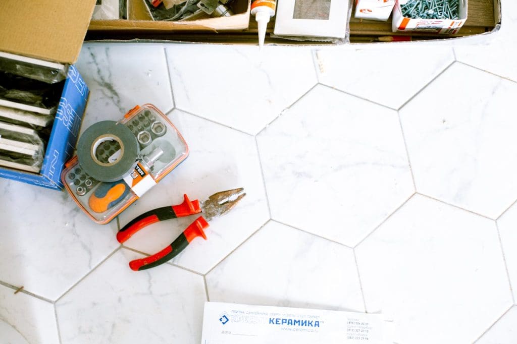tools-on-the-floor-3615716 A selection of home renovation tools placed on a white tiled floor, ready for use.